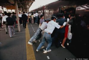 Japan, Honshu, Tokyo, railway staff squeezing commuters onto train